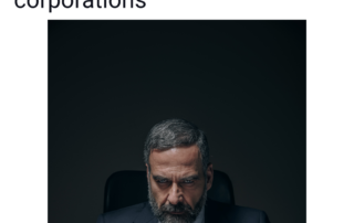 Evil business person glares directly over a desk with a laptop. The scowl of the man intesifies with a piercing gaze as he rests his elbows over the desk while arching his fingers together in sign of superiority.
